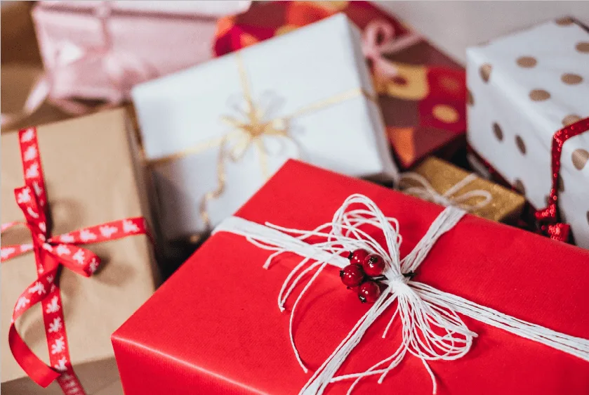 Assortiment d'idées de cadeaux économiques pour Secret Santa dans un ensemble cadeau emballé de façon festive.
